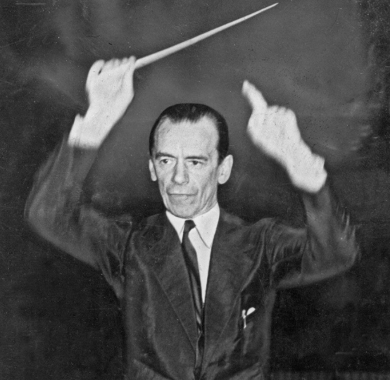 Sir Malcolm Sargent Half figure of Sir Malcolm Sargent conducting, his right arm raised holding a baton and his left arm also raised pointing his finger upwards